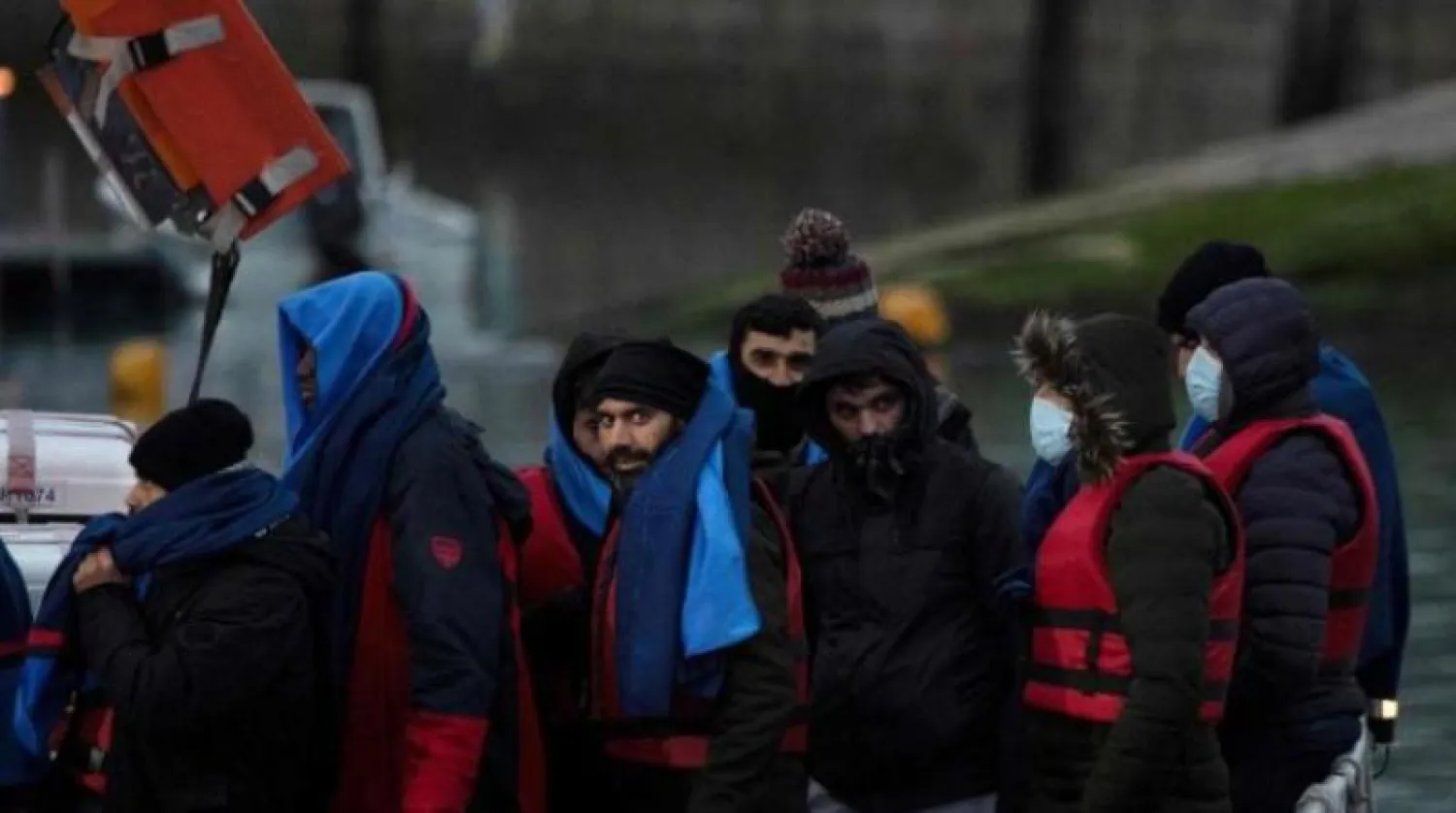 مهاجرون يغادرون قارب نجاة عند وصولهم إلى مارينا في دوفر جنوب شرقي إنجلترا (أ.ف.ب)