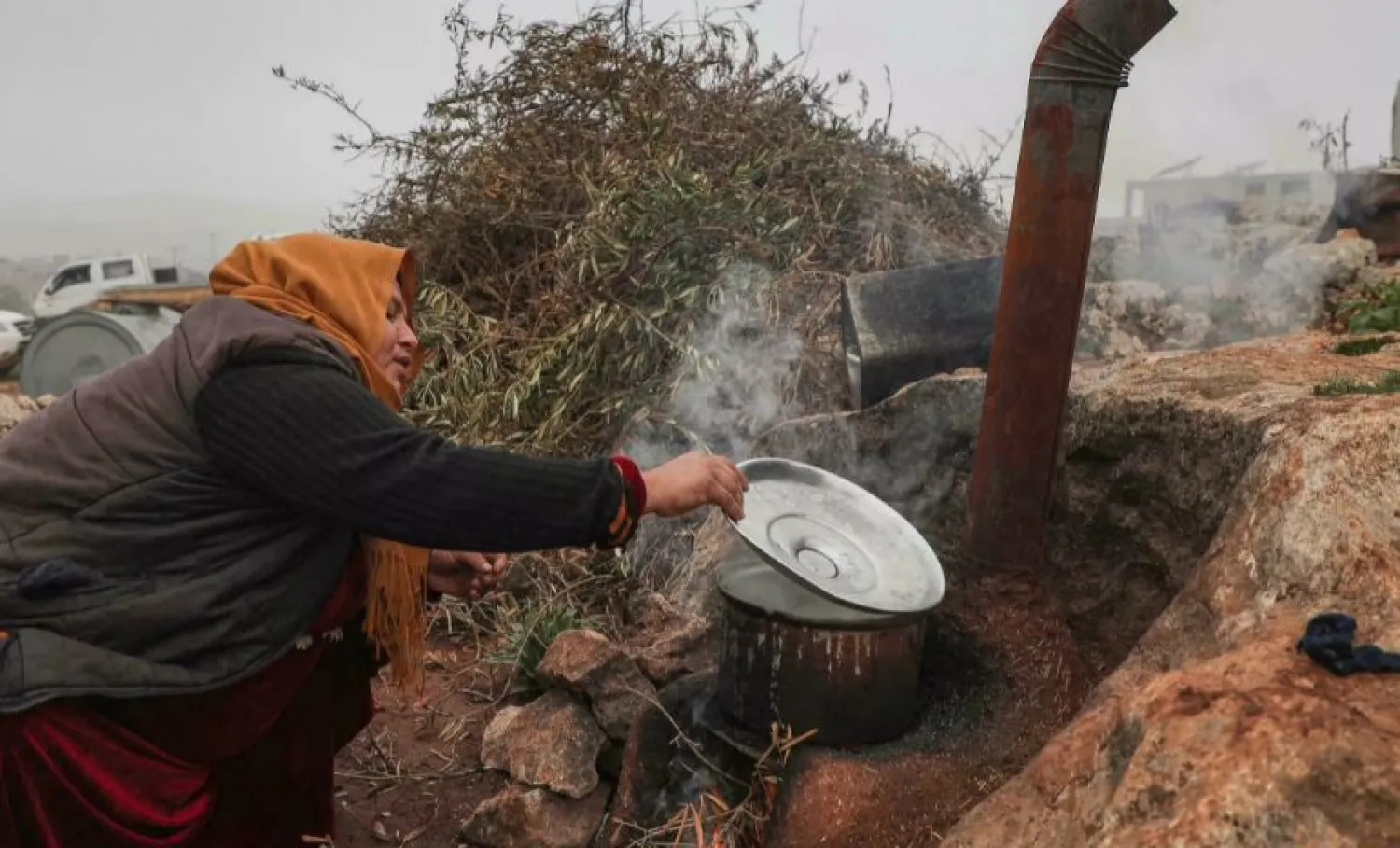 Umm Mohammad cooks outside at a makeshift displacement camp in Syria's Idlib province Aaref WATAD AFP
