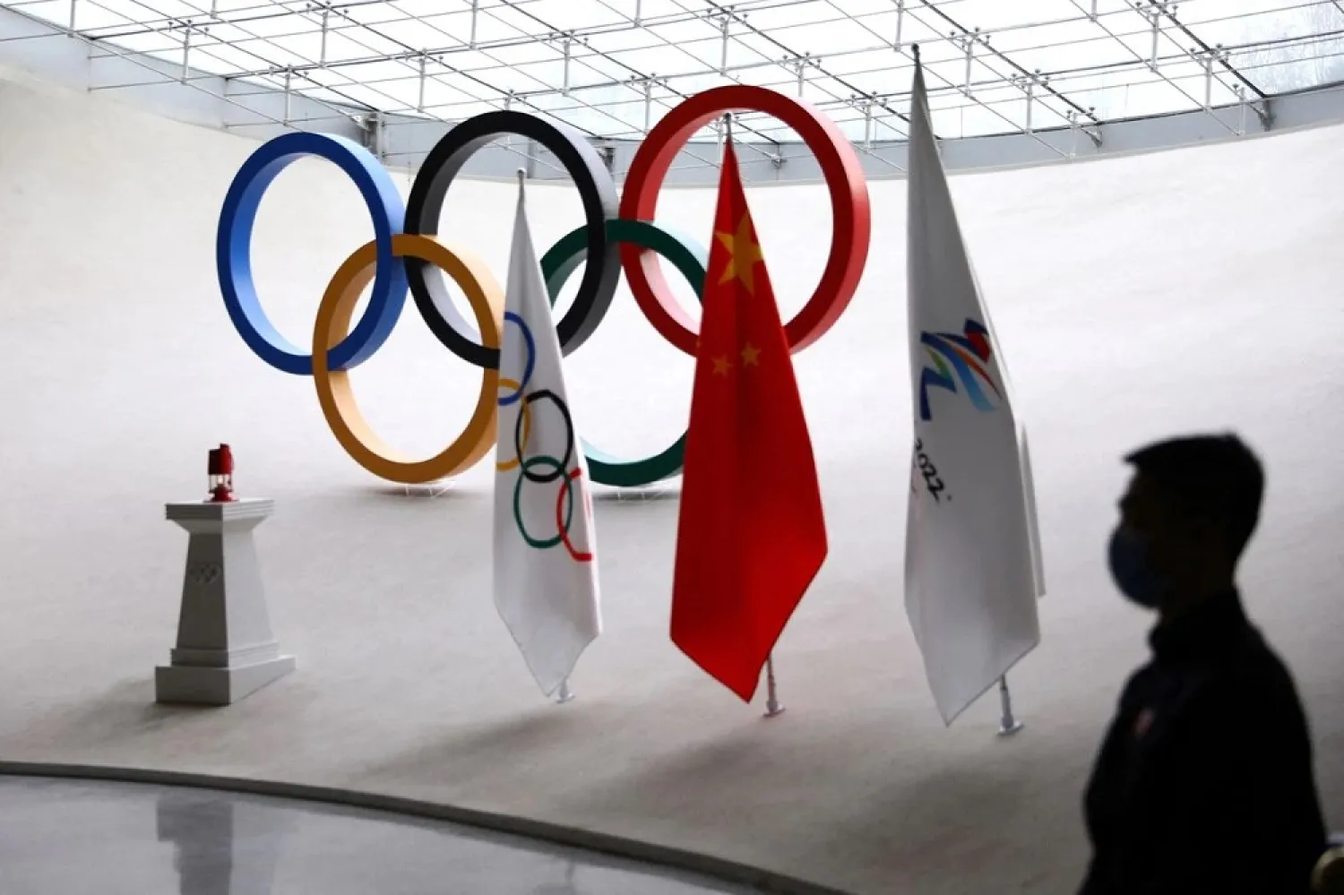 A staff member stands guard near a safety lantern carrying the Olympic flame of the Beijing 2022 Winter Olympics that is displayed inside the Olympic Tower, in Beijing, China December 10, 2021. (Reuters)