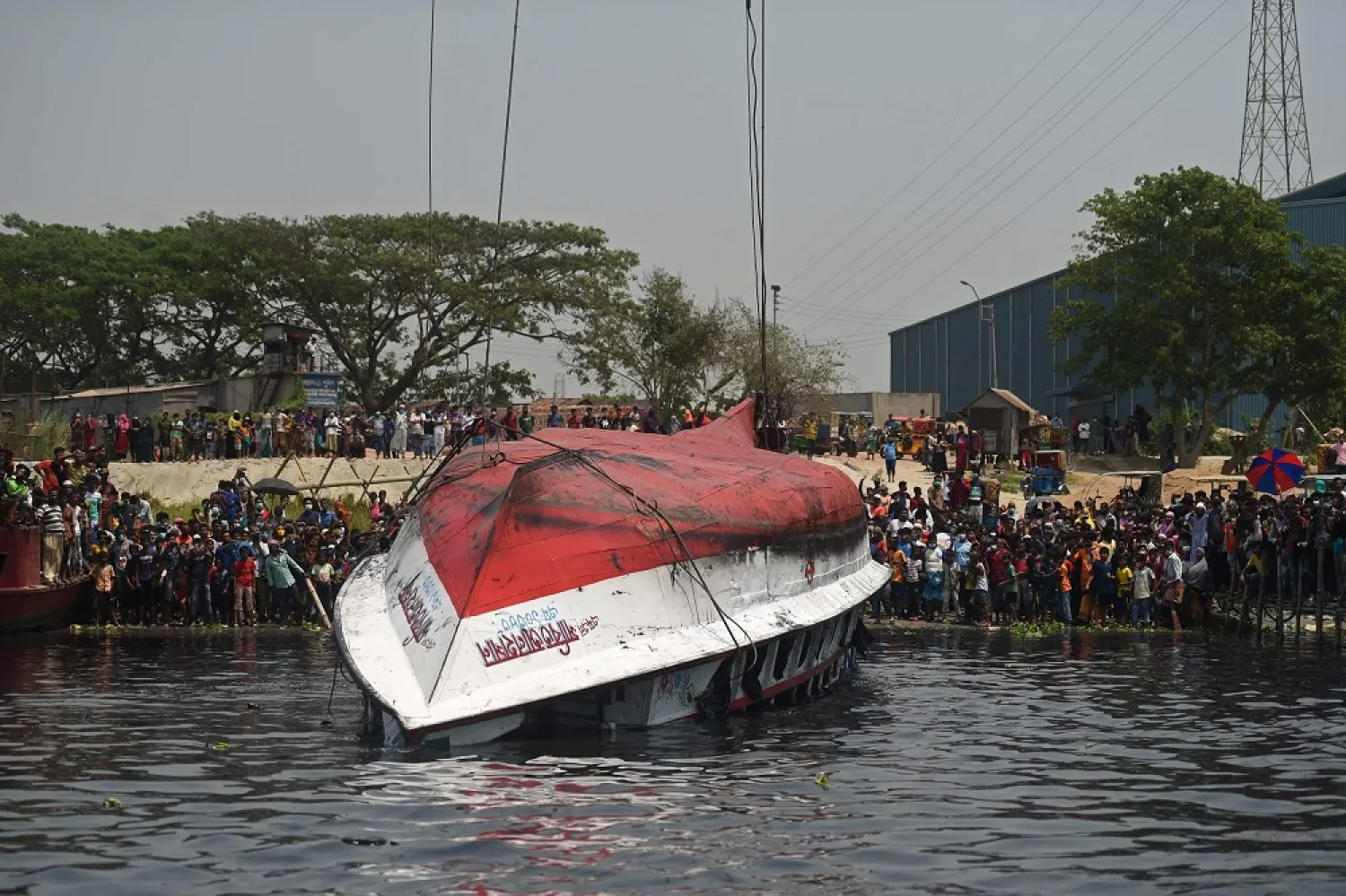 Onlookers and relatives gather after the authorities recovered the capsized boat in Shitalakshya River, in Narayanganj, Bangladesh, April 5, 2021. (AFP)
