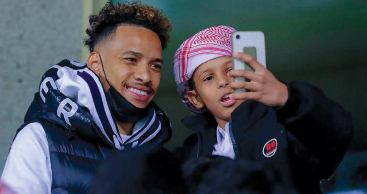 بيريرا يتلقط صورة مع أحد الأطفال في مدرجات  ملعب الأمير فيصل بن فهد أمس «تصوير: علي الظاهري»