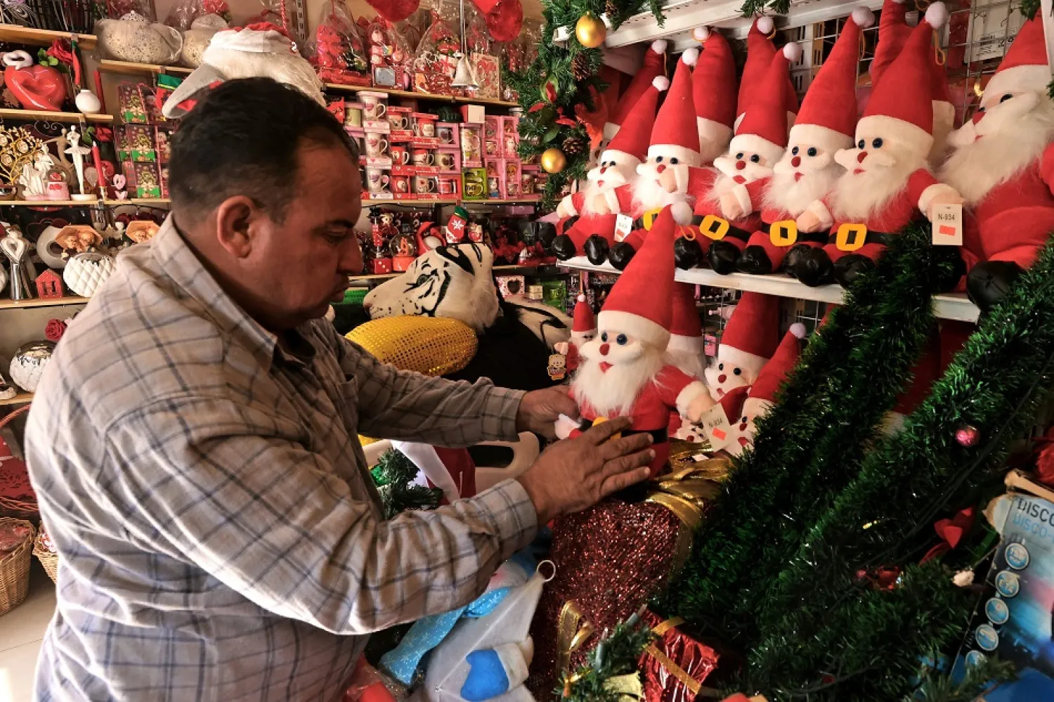 Iraklı bir satıcı, Bağdat'taki dükkanında Noel eşyaları satıyor (AFP)

