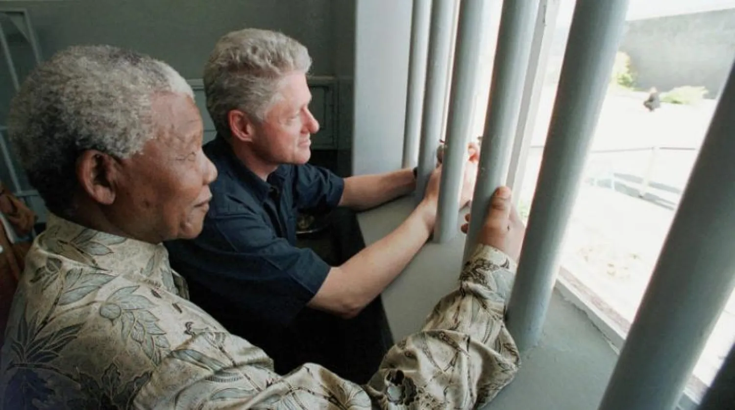 Nelson Mandela ve Eski ABD Başkanı Bill Clinton, 1998 yılında Mandela’nın kaldığı 1 numaralı hücreyi ziyaret ederken (AP)