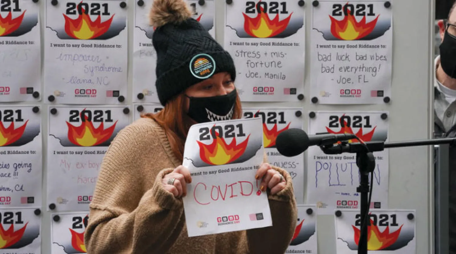 فتاة بساحة تايمز سكوير بنيويورك ورسالة للتخلص من كوفيد في يوم التخلي عن الذكريات السيئة خلال العام (أ.ف.ب)