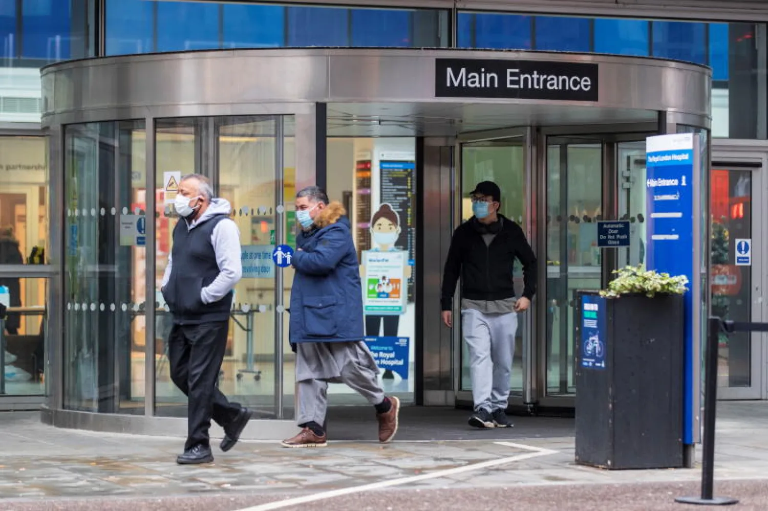 أشخاص يضعون كمامات أمام أحد مستشفيات لندن (رويترز)