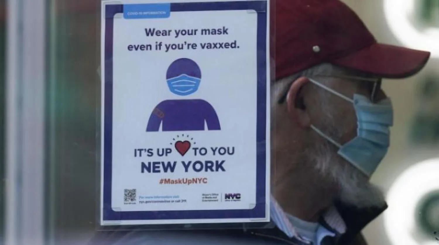 لافتة تذكّر الزبائن بارتداء الكمامة في متجر بمدينة نيويورك (أ.ب)