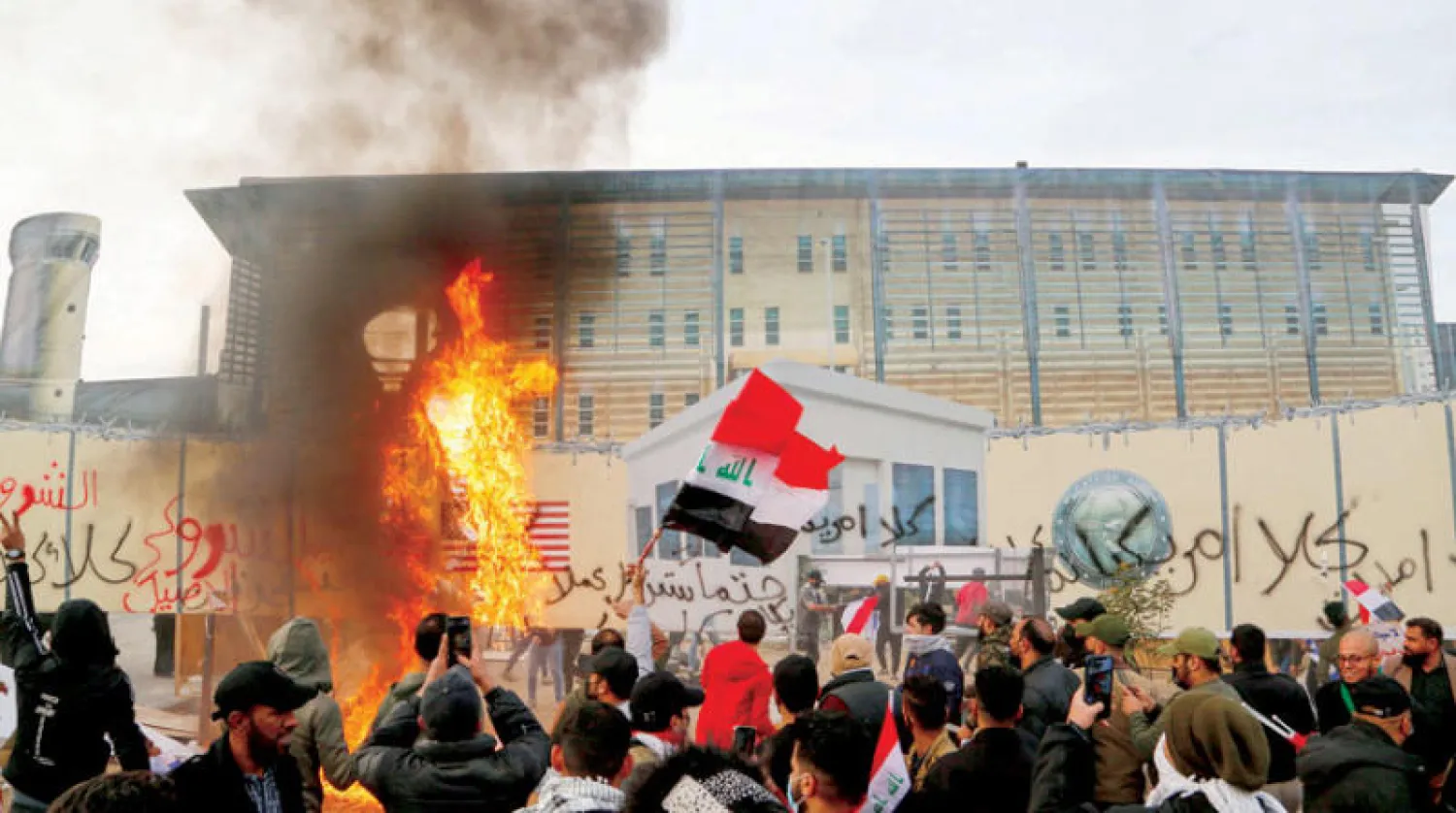 أنصار {الحشد} خلال احتجاج ضد الولايات المتحدة أمام إحدى بوابات المنطقة الخضراء أمس (رويترز)