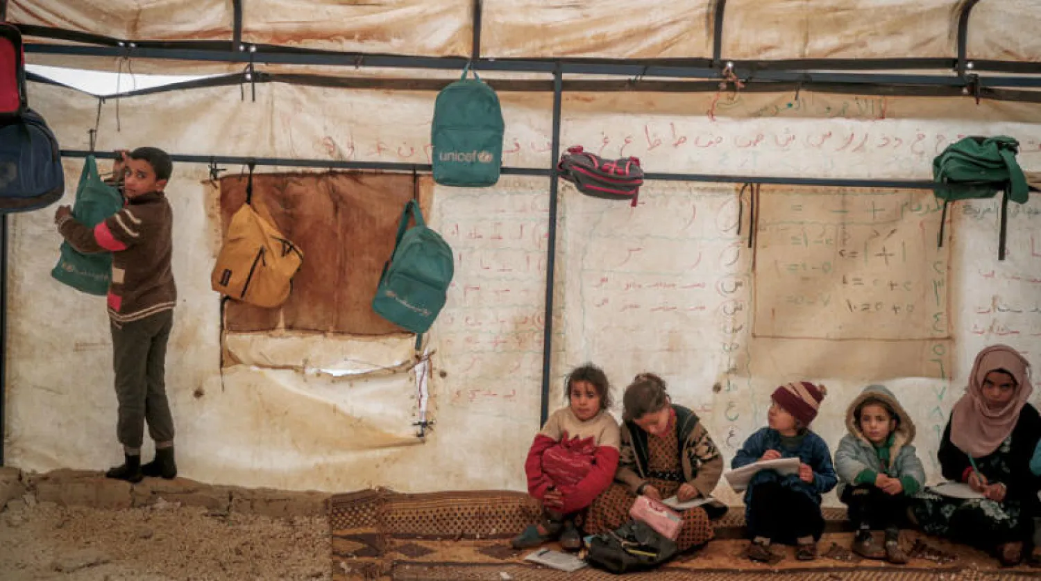 أطفال في خيمة تحولت إلى صف دراسي في مخيم للنازحين بقرية كللي بمحافظة إدلب شمال غربي سوريا الثلاثاء الماضي (د.ب.أ)