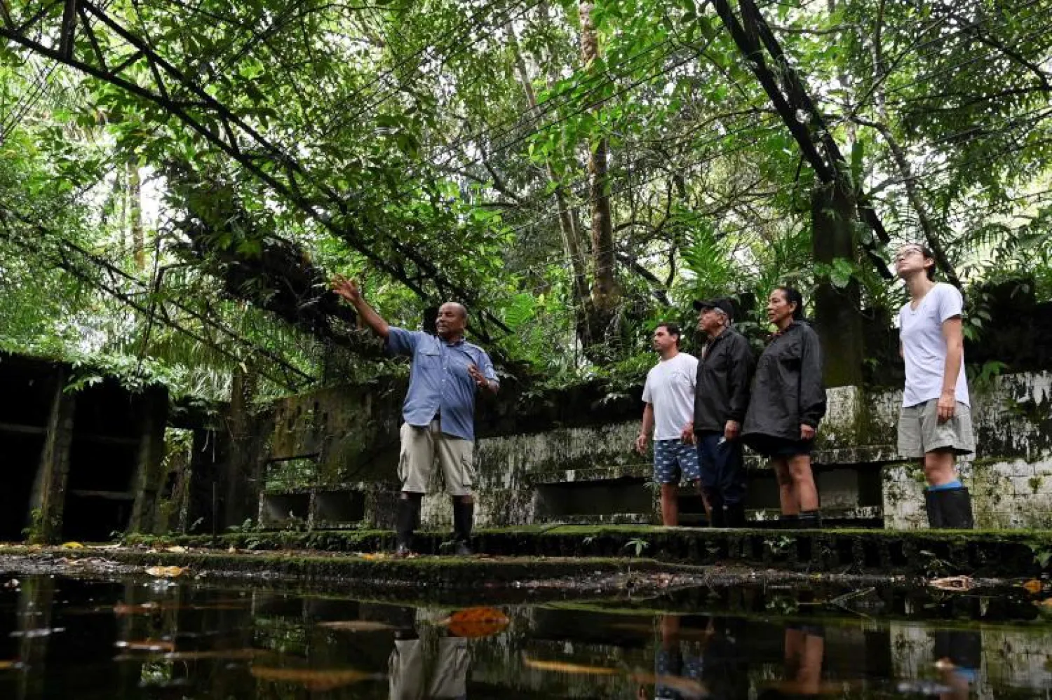 أحد عمال المُتنزه في جزيرة غورغونا يتحدث مع السياح في مكان السجن (أ.ف.ب)