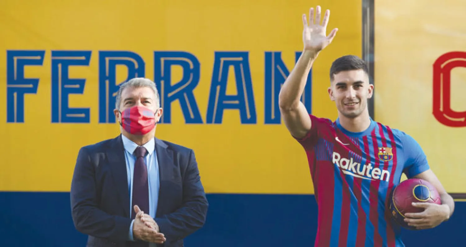 لابورتا (يسار) يقدم فيرا توريس لجماهير برشلونة (إ.ب.أ)