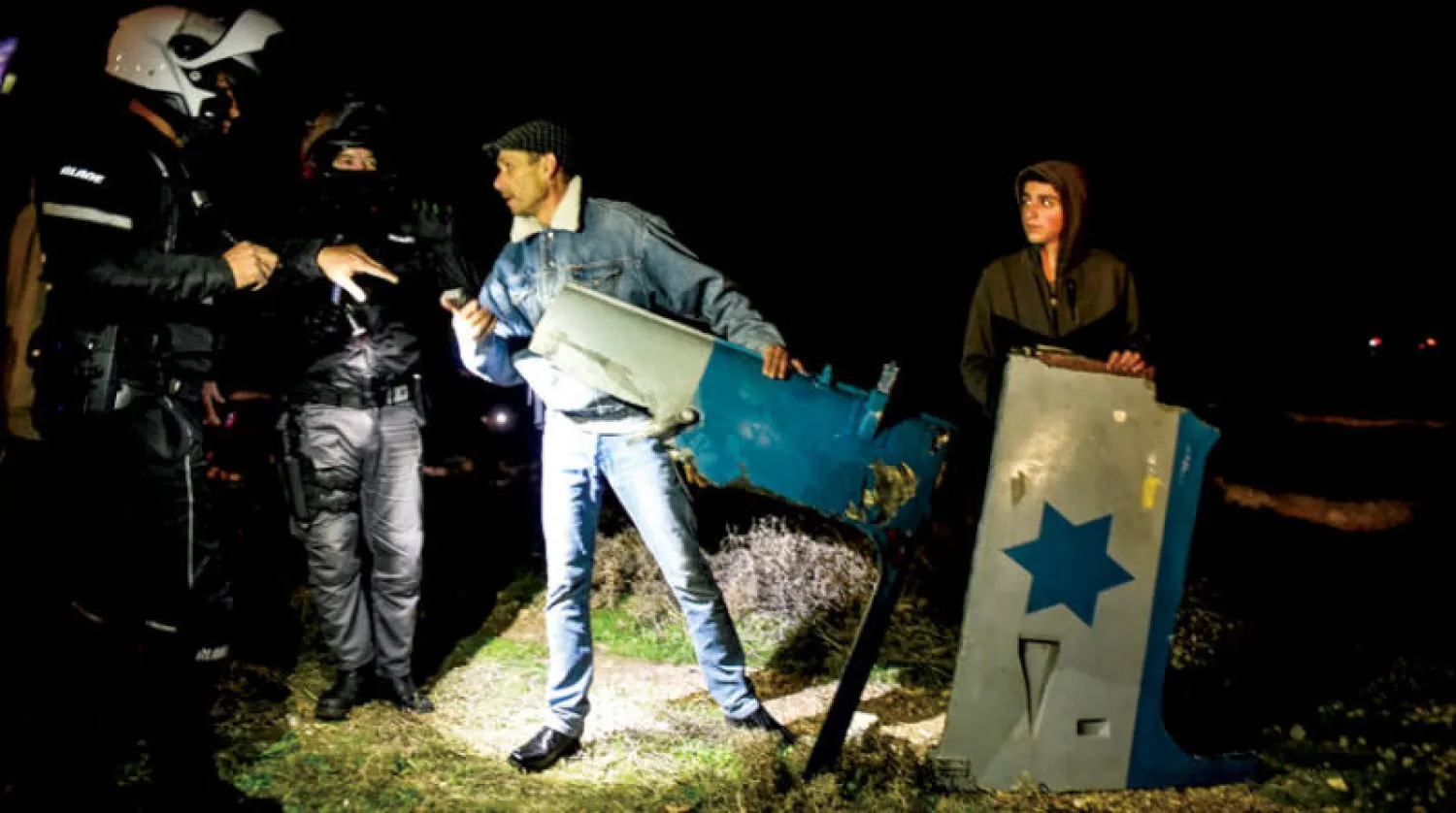 أفراد من الشرطة الإسرائيلية يحملون أجزاء من مروحية بعد تحطمها قبالة ساحل البحر قرب حيفا (رويترز)