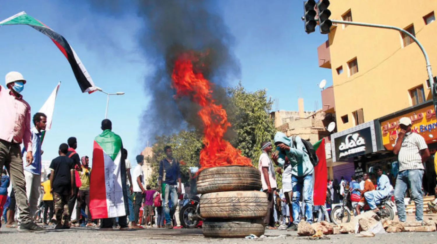 محتجون يشعلون الإطارات في شارع الأربعين في أم درمان أمس (أ.ف.ب)