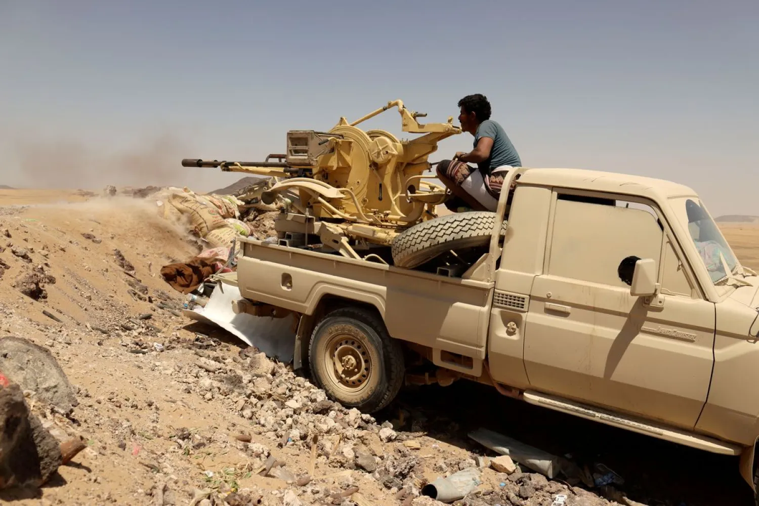 A Yemeni government fighter fires a vehicle-mounted weapon at a frontline position during fighting against the Houthis in Marib, Yemen March 28, 2021. Picture taken March 28, 2021. (Reuters)