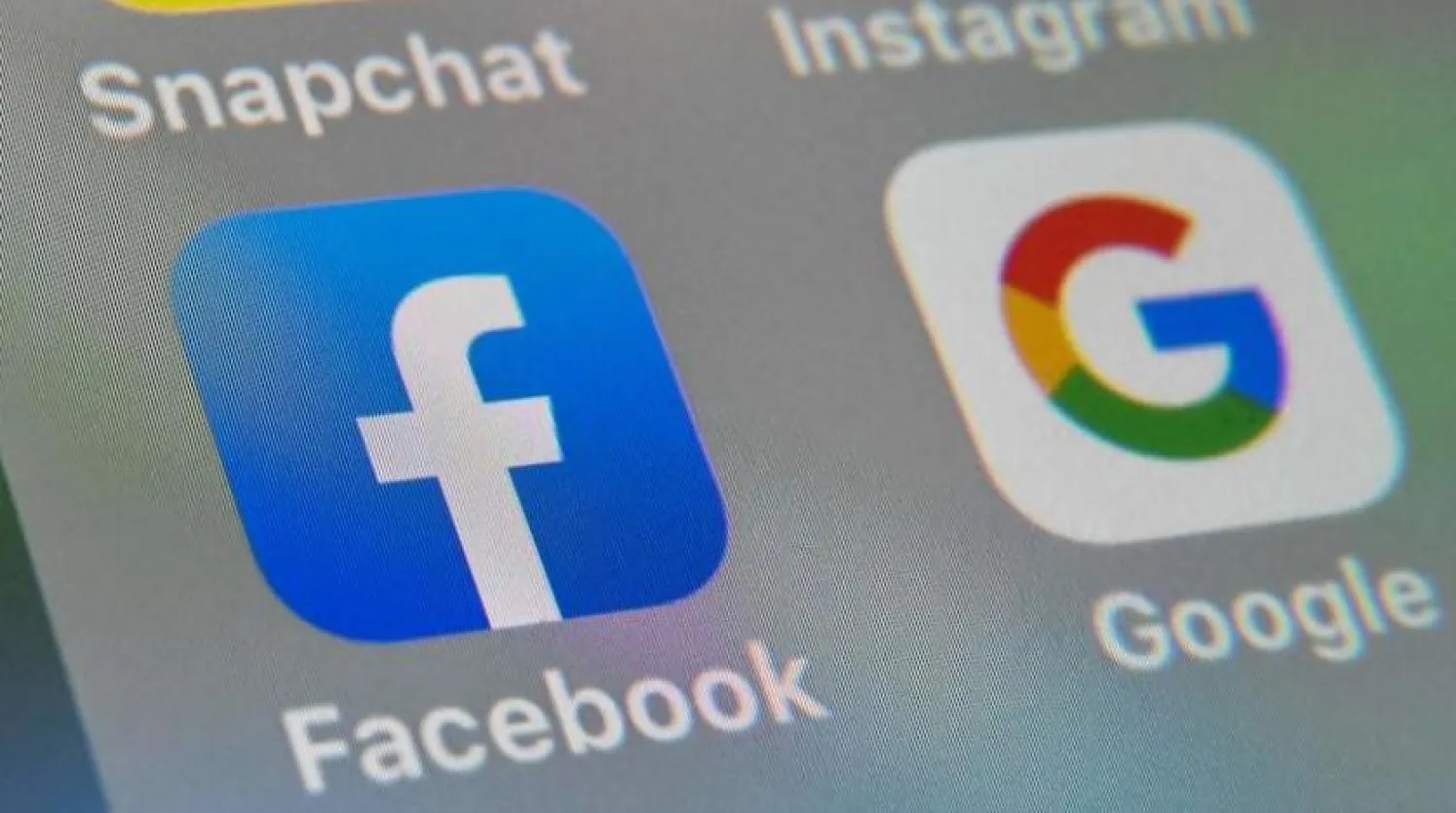 Bir mobil cihazdaki Facebook ve Google uygulamalarının logoları (AFP)