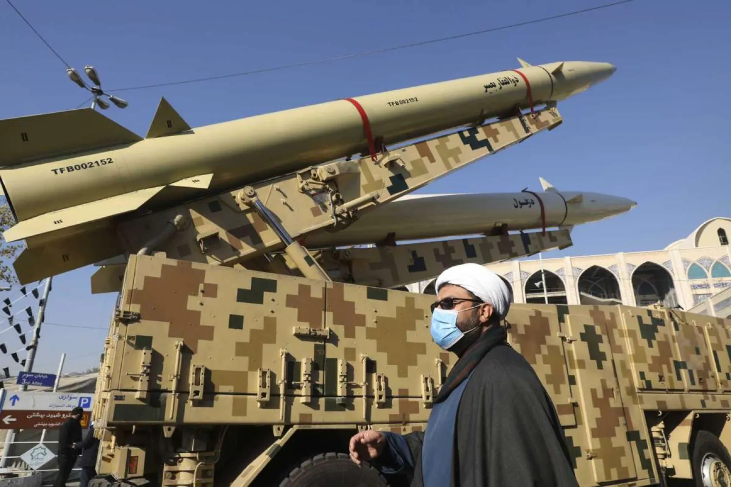 A cleric walks past Zolfaghar, top, and Dezful missiles displayed in a missile capabilities exhibition by the paramilitary Revolutionary Guard in Tehran, Iran, Friday, Jan. 7, 2022. (AP Photo/Vahid Salemi)
