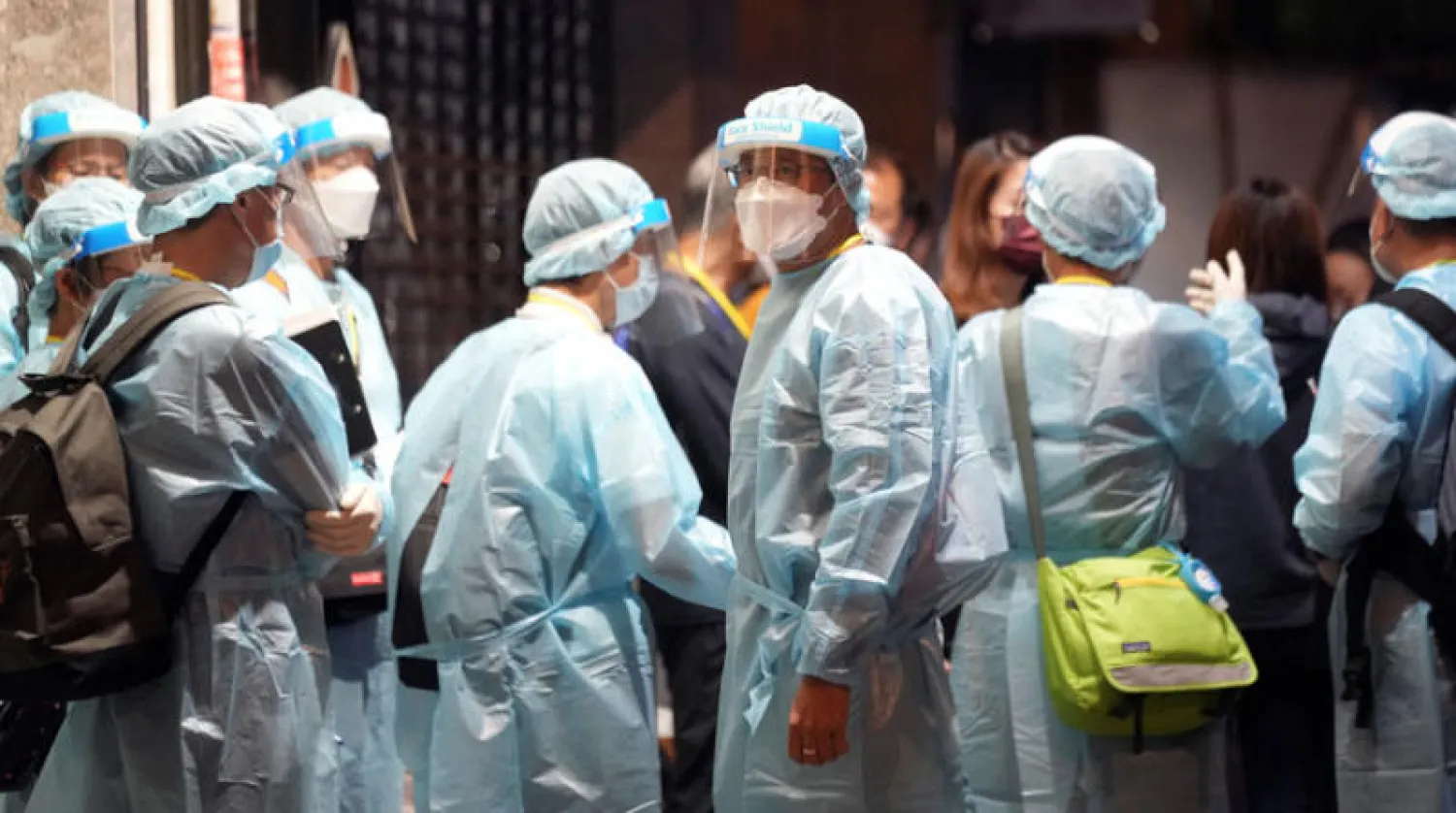 طاقم الصحي يصل إلى برج سكني تحت الحجر في هونغ كونغ 7 يناير (رويترز)