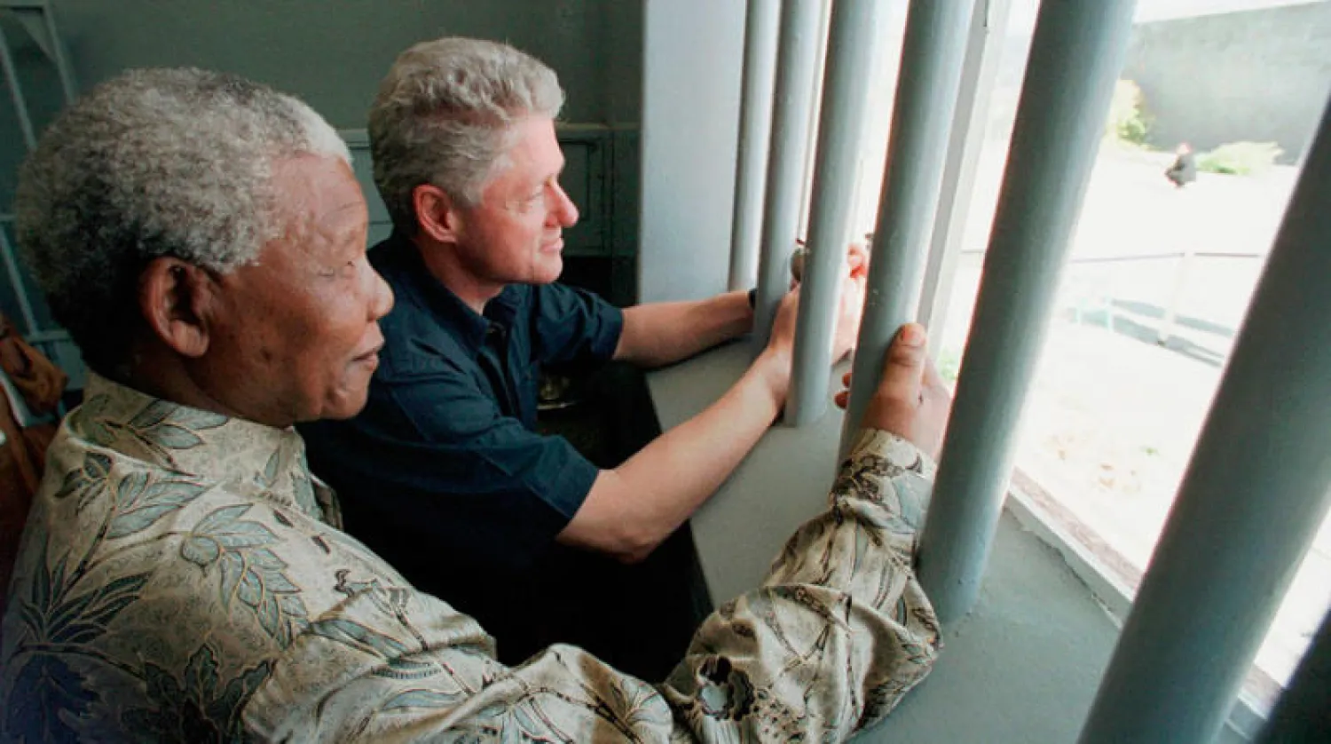 نيلسون مانديلا وبيل كلينتون يزوران زنزانة الزعيم الأفريقي في مارس 1998 (أ.ب)