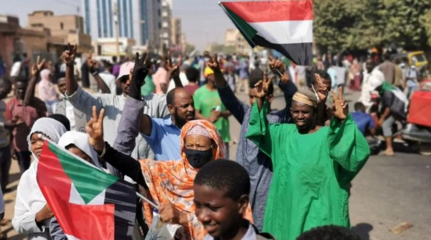 Sudanlı göstericiler başkent Hartum'daki bir protesto sırasında ulusal bayraklar kaldırdı (AFP)
