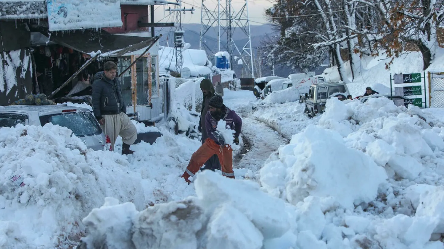 People work to clear a road after a deadly blizzard struck Murree, around 70 kilometers (45 miles) northeast of the Pakistan capital, Islamabad. (AFP)
