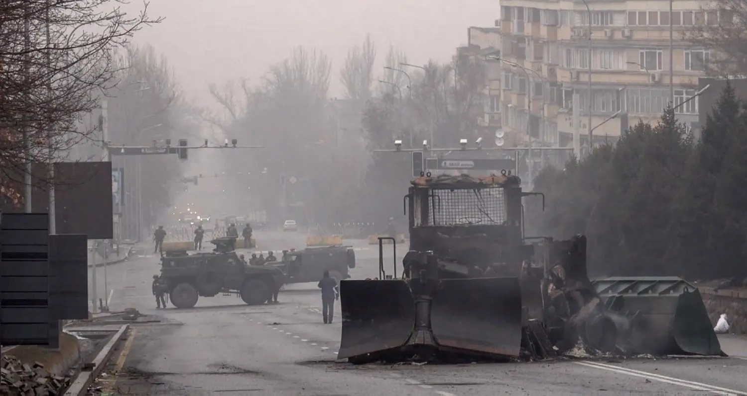 Servicemen and their military vehicles block a street in central Almaty on January 7, 2022, after violence that erupted following protests over hikes in fuel prices. (AFP)