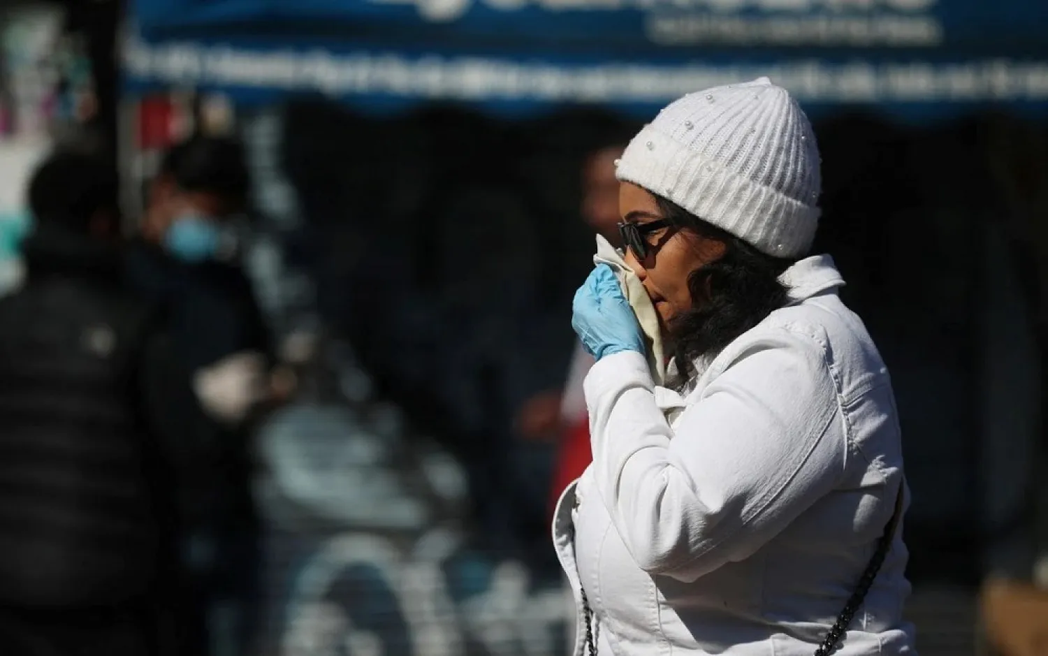 A woman blows her nose in Dalston as the spread of the coronavirus disease (COVID-19) continues, London, Britain, April 14, 2020. (Reuters)