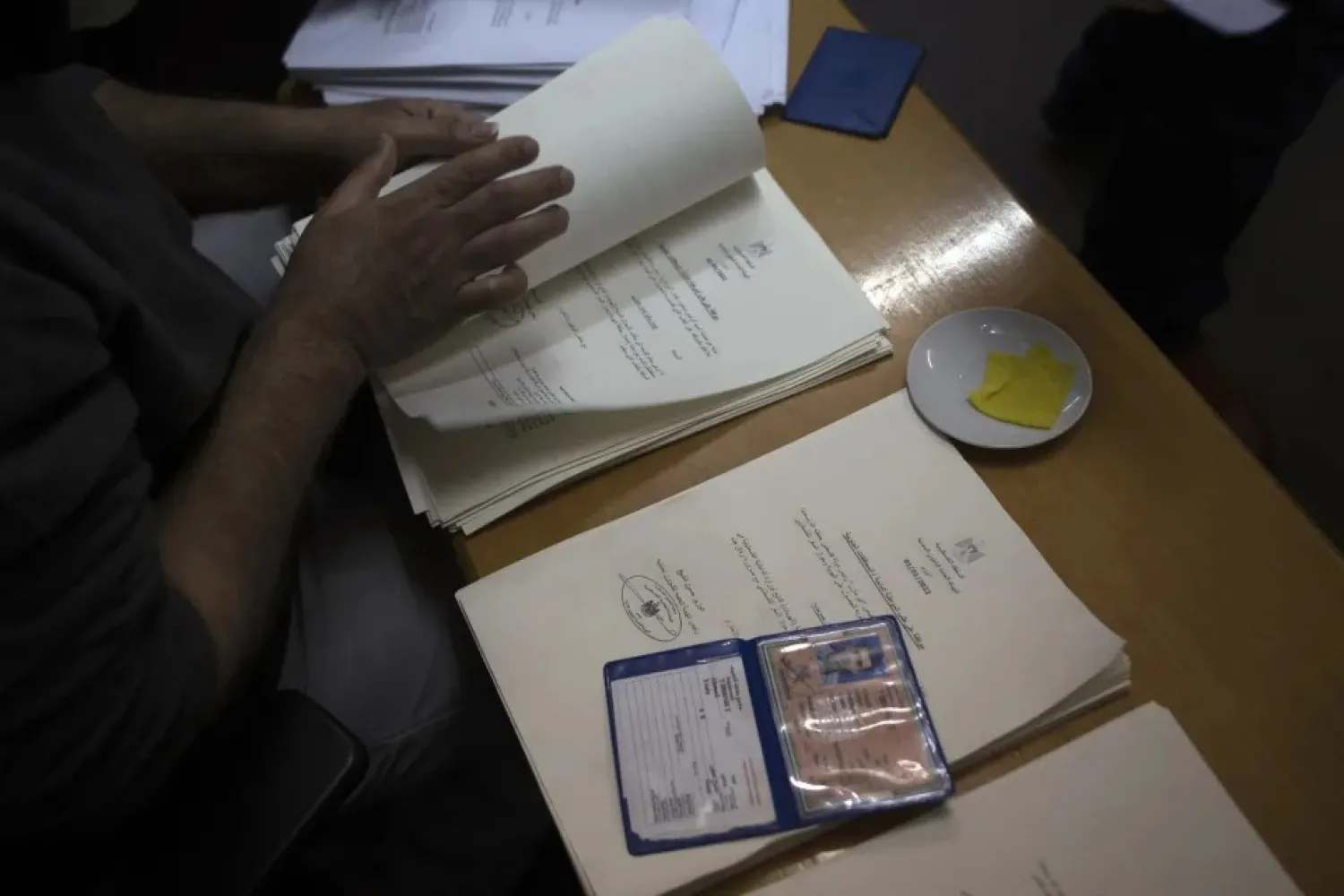 A Palestinian civil affairs employee looks for a name among the letters officially approved by Israel, in his office in Gaza City, Monday, Jan. 3, 2022. (AP Photo/ Khalil Hamra)
