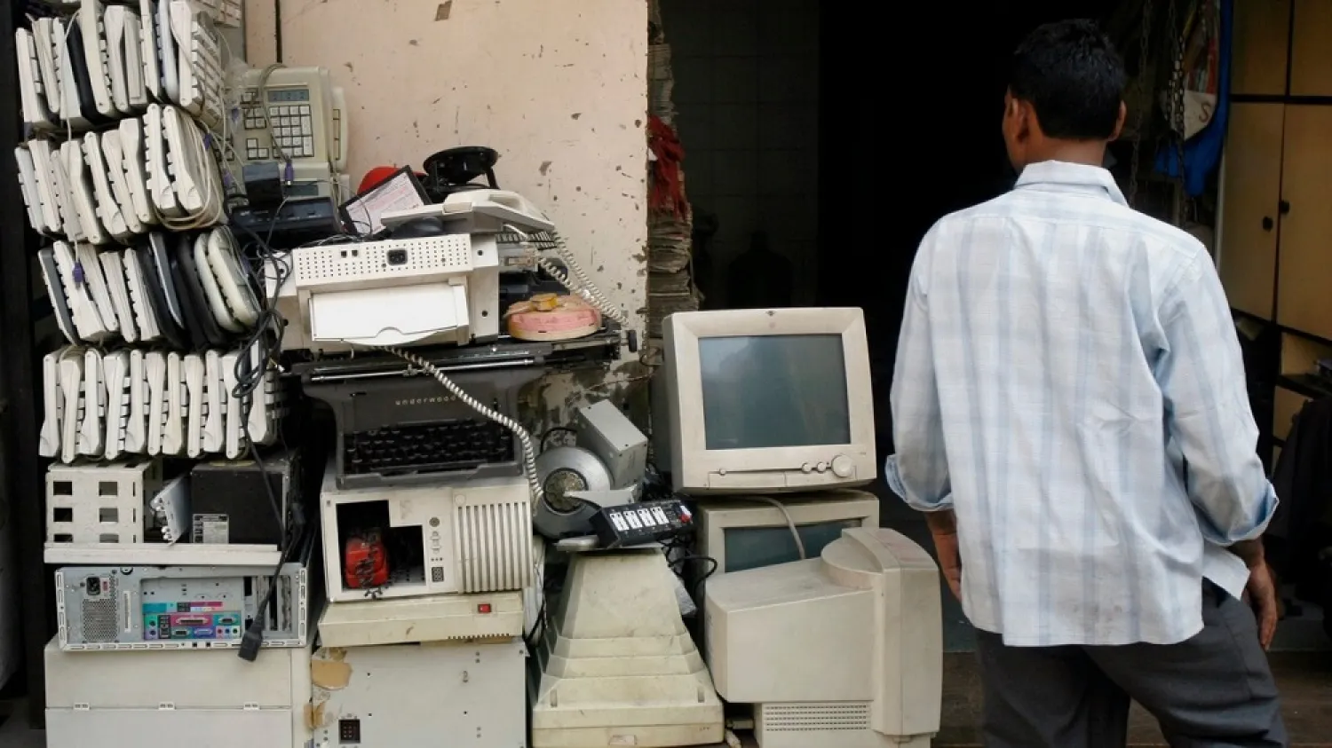 A man walks past electronic waste at a junk shop in Mumbai. (Reuters)