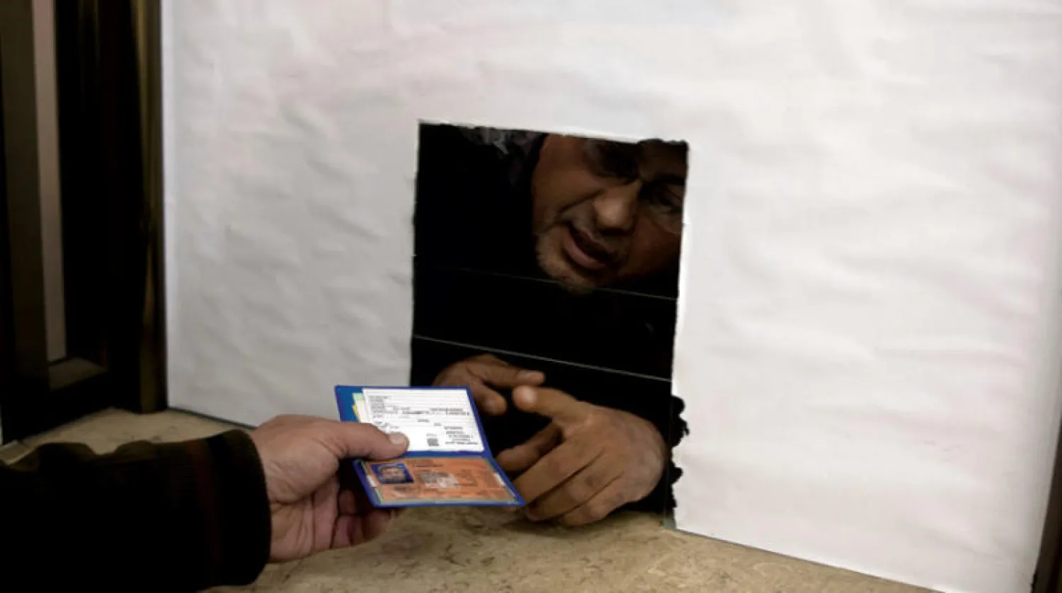 فلسطيني يقدم هويته المؤقتة ليحصل على هوية دائمة من مكتب الشؤون المدنية بغزة (أ.ب)