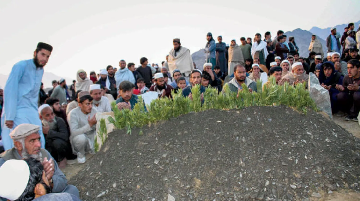 مشيعون أفغان يؤدون صلاة الجنازة قرب موقع دفن أحد ضحايا انفجار في كشك لبيع الفشار بجوار مدرسة بإقليم ننغرهار أول من أمس (أ.ف.ب)