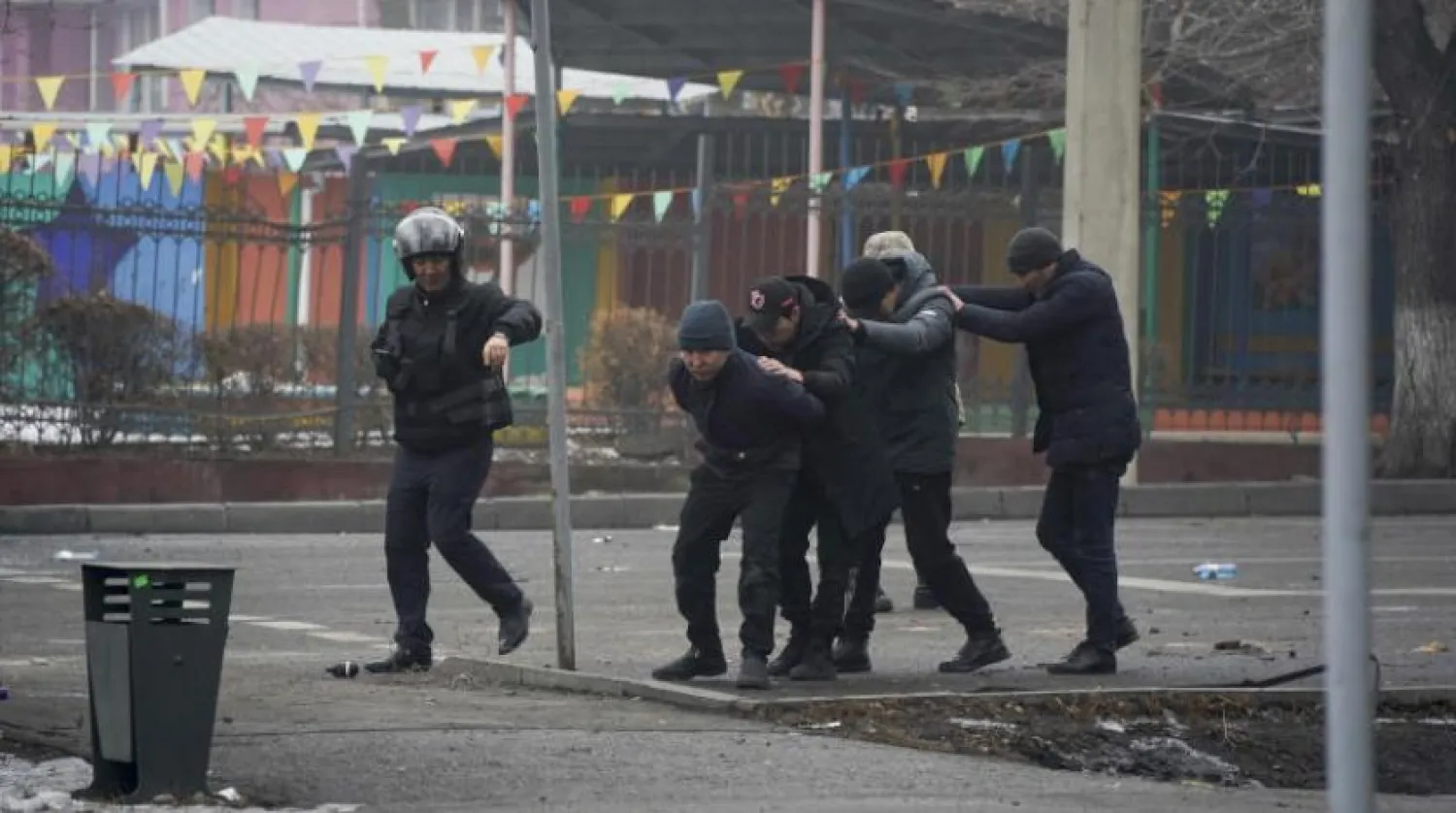 Kazakistan polisi bir grup protestocuyu gözaltına alıyor (AP)