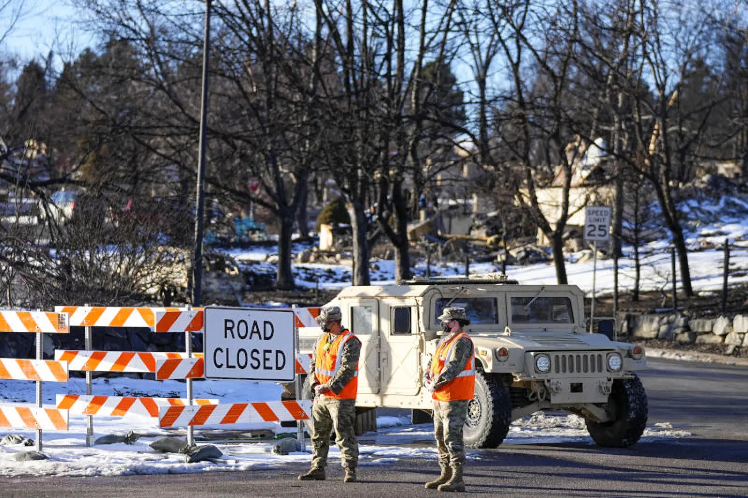 عنصران من الحرس الوطني يرتديان كمامتين ويقفان بالقرب من طريق مقطوع في الولايات المتحدة (أ.ب)