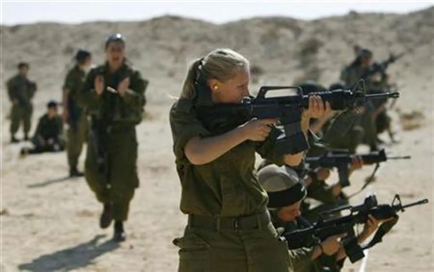 FILE: Female Israeli soldiers fire their weapons during a training session at military base in southern Israel February 12, 2007.REUTERS/Eliana Aponte


