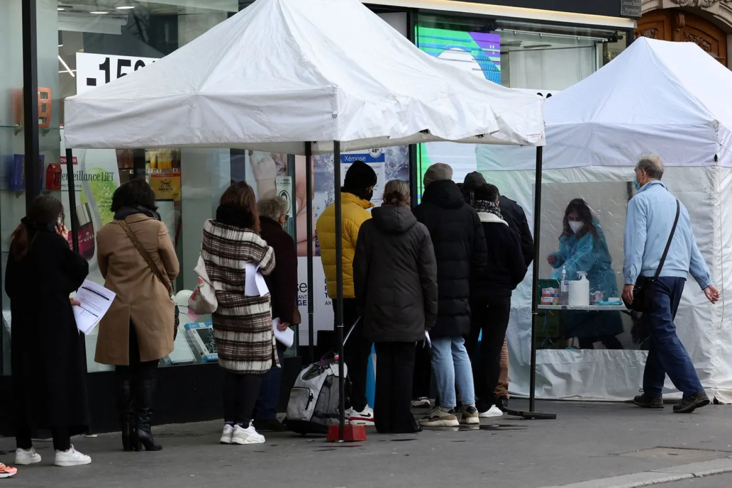 People queue for COVID-19 tests in front of a testing booth outside a pharmacy in Paris amid the spread of the coronavirus disease (COVID-19) pandemic in France, January 7, 2022. REUTERS/Sarah Meyssonnier