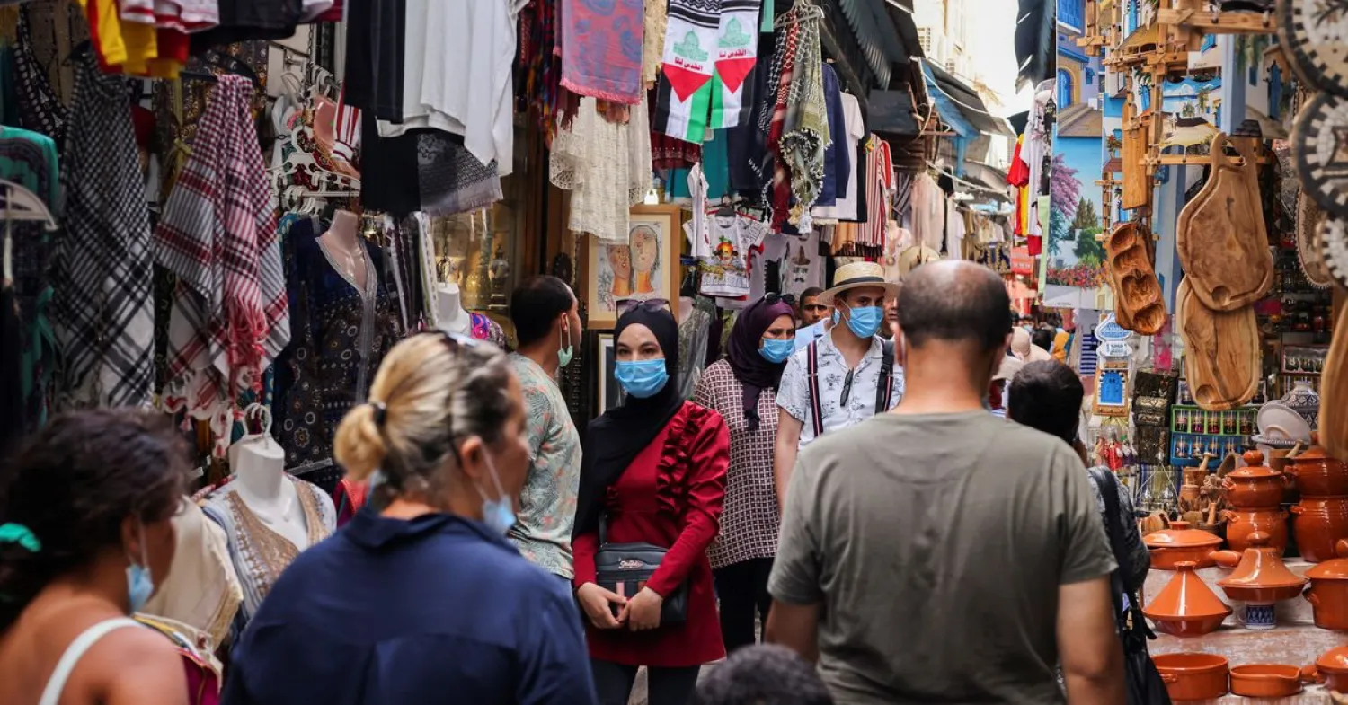 People wearing protective face masks walk past shops, amid the coronavirus disease (COVID-19) outbreak, in the Old City of Tunis, Tunisia, August 3, 2021. REUTERS/Ammar Awad


