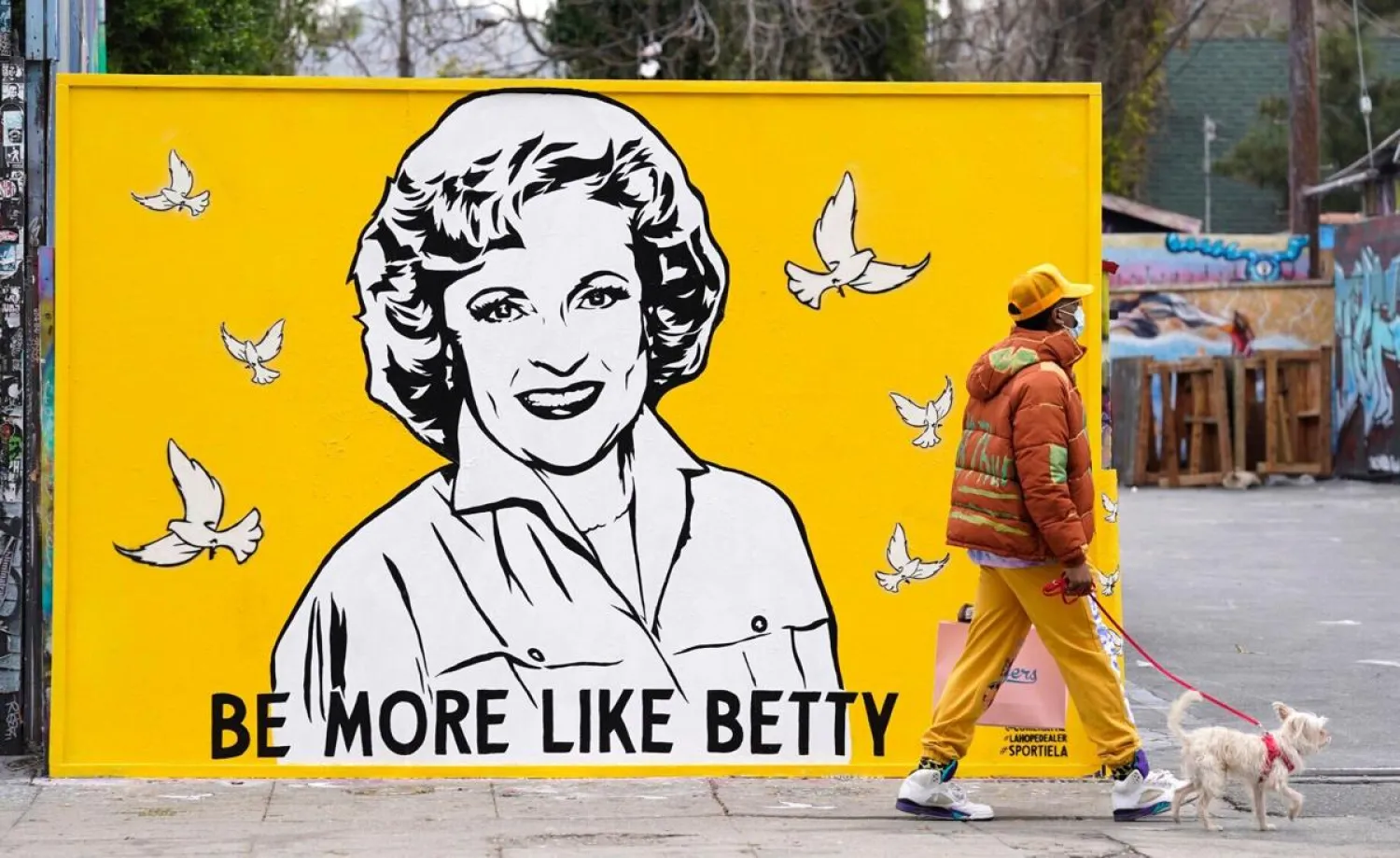 A man walks a dog past a new mural of the late actress Betty White by artist Corie Mattie, Tuesday, Jan. 13, 2022, in Los Angeles. (AP)