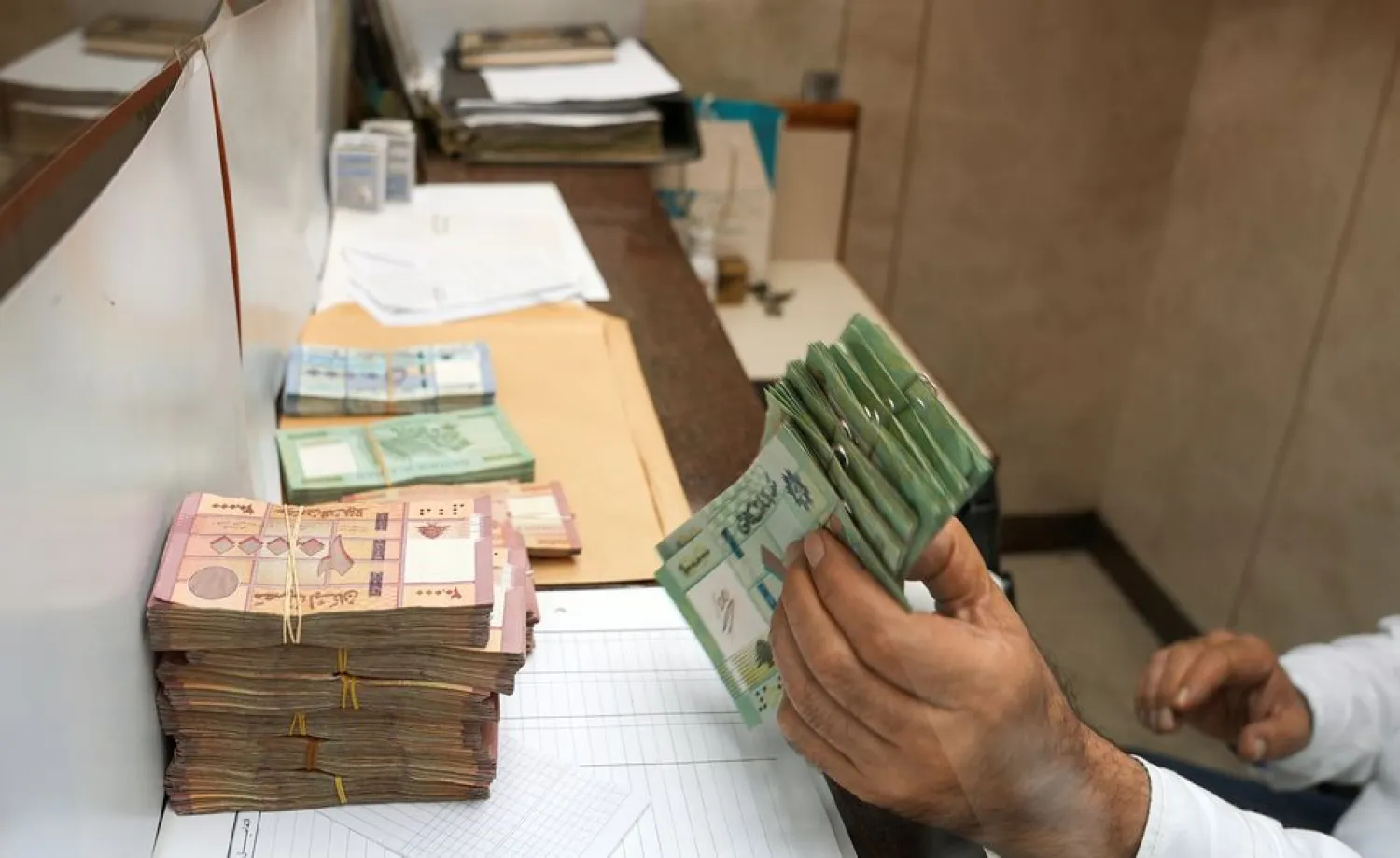 A man holds up Lebanese pound banknotes in Beirut, Lebanon October 27, 2021. Picture taken October 27, 2021. (Reuters)