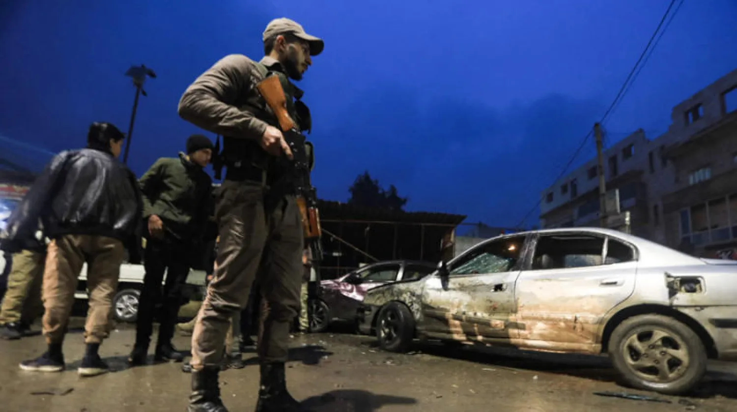 مقاتل من المعارضة السورية قرب موقع الانفجار في سوق بمدينة الباب بمحافظة حلب أول من أمس (أ.ف.ب)