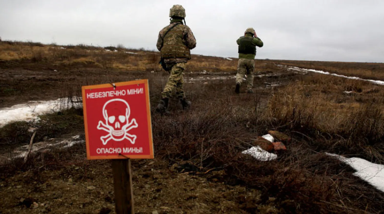 جنديان أوكرانيان يتجاوزان تحذيرا من الألغام في منطقة مواجهة مع الانفصاليين بدونيتسكو 11 يناير (أ.ف.ب)