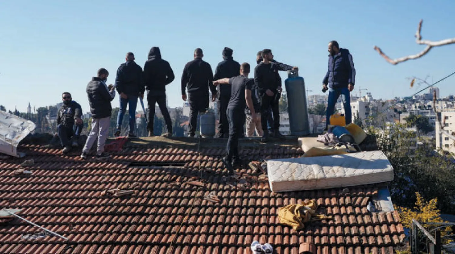 سكان منزل في حي الشيخ جراح مطلوب إخلاؤه يعتلون سطحه مهددين بحرق أنفسهم بعبوات وقود أمس (أ.ب)