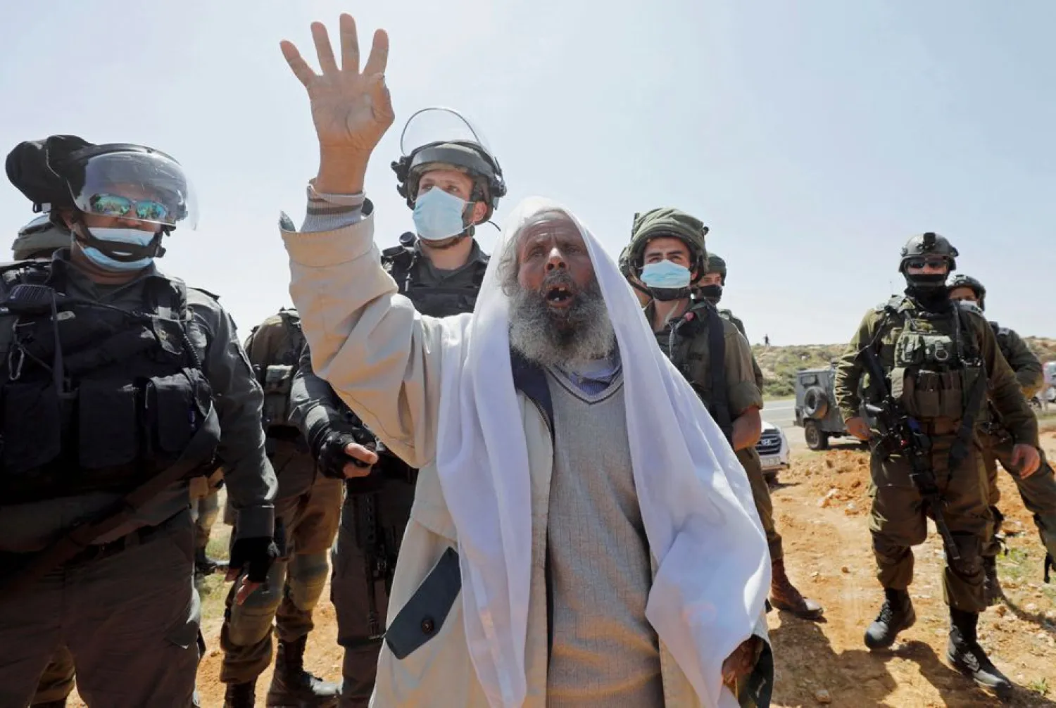 Palestinian Suleiman al-Hathalin reacts in front of Israeli troops during a protest against Israeli settlements, in Yatta in the Israeli-occupied West Bank on March 19, 2021. Reuters