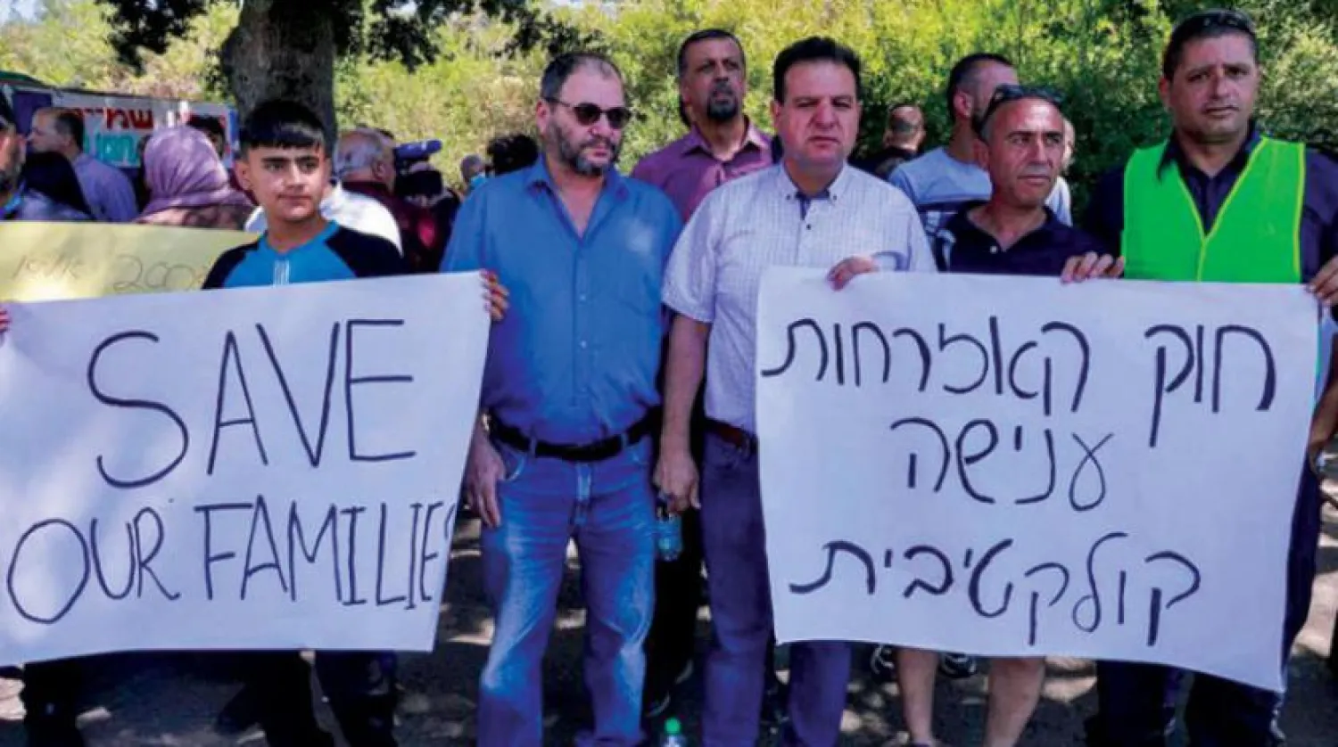 Eymen Avde ve Ahmed et-Tıybi’nin de aralarında bulunduğu Ortak Arap Listesi Bloku milletvekilleri Haziran ayında Meclis’in birleştirme kararını protesto eden kalabalığın arasında (AFP)