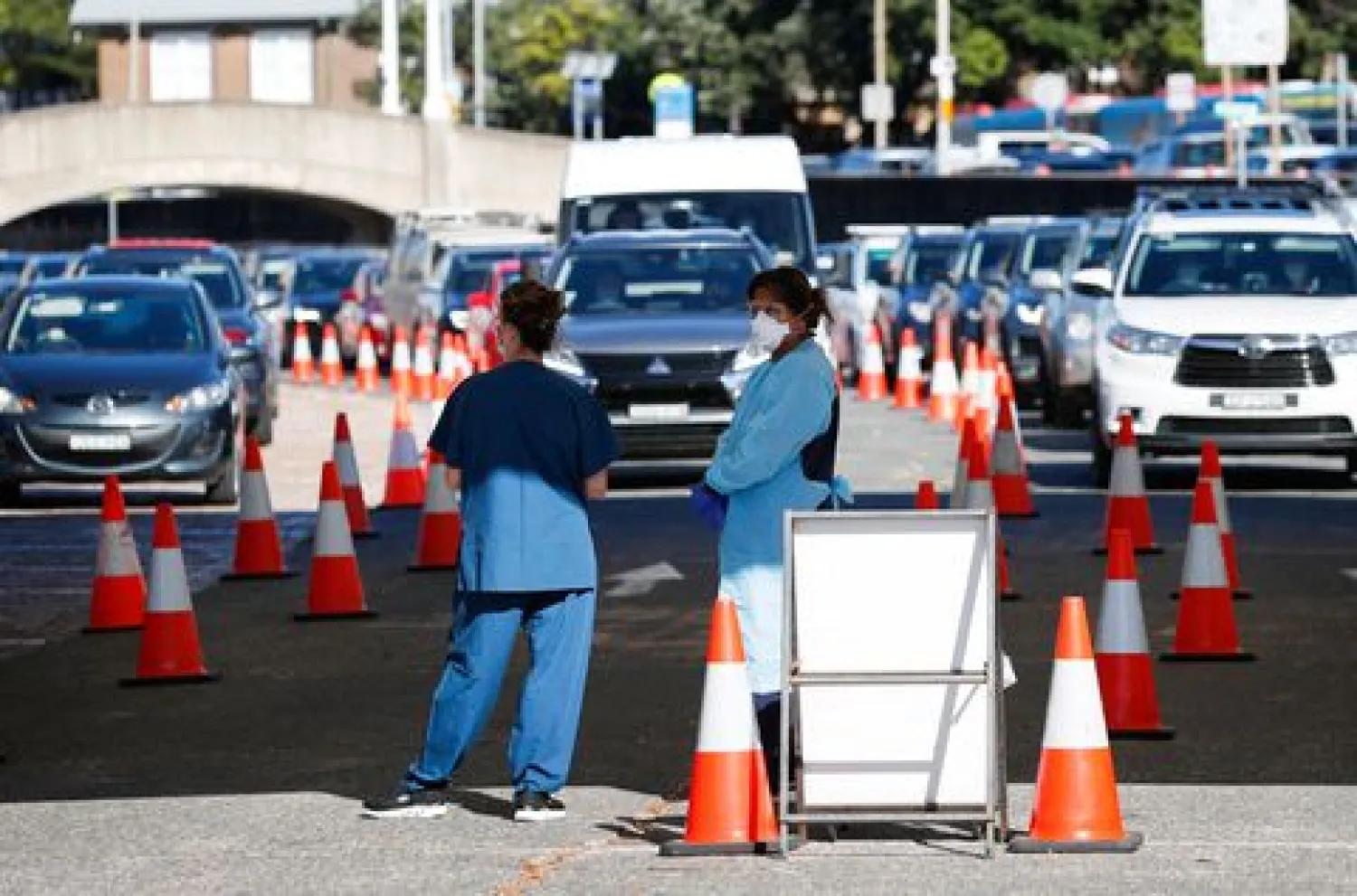 Healthcare workers wait for the next vehicle at a coronavirus disease (COVID-19) testing clinic as the Omicron coronavirus variant continues to spread in Sydney, Australia, December 30, 2021. REUTERS/Nikki Short



