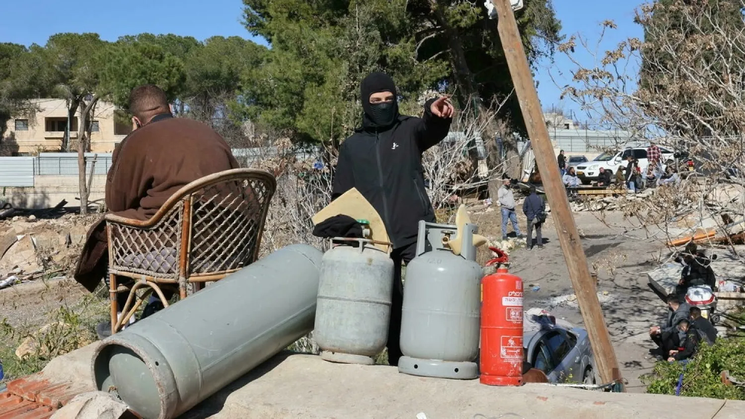 Members of the Palestinian Salhiya family sit on the roof of their home beside gas canisters as they protest an eviction attempt by Israeli Police and Jerusalem municipality. (AFP)