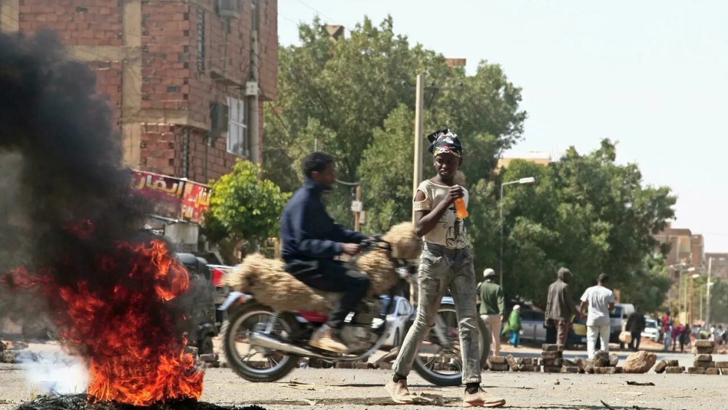 Sudanese demonstrators barricade a street in Khartoum Tuesday amid ongoing protests against a military coup. (AFP)