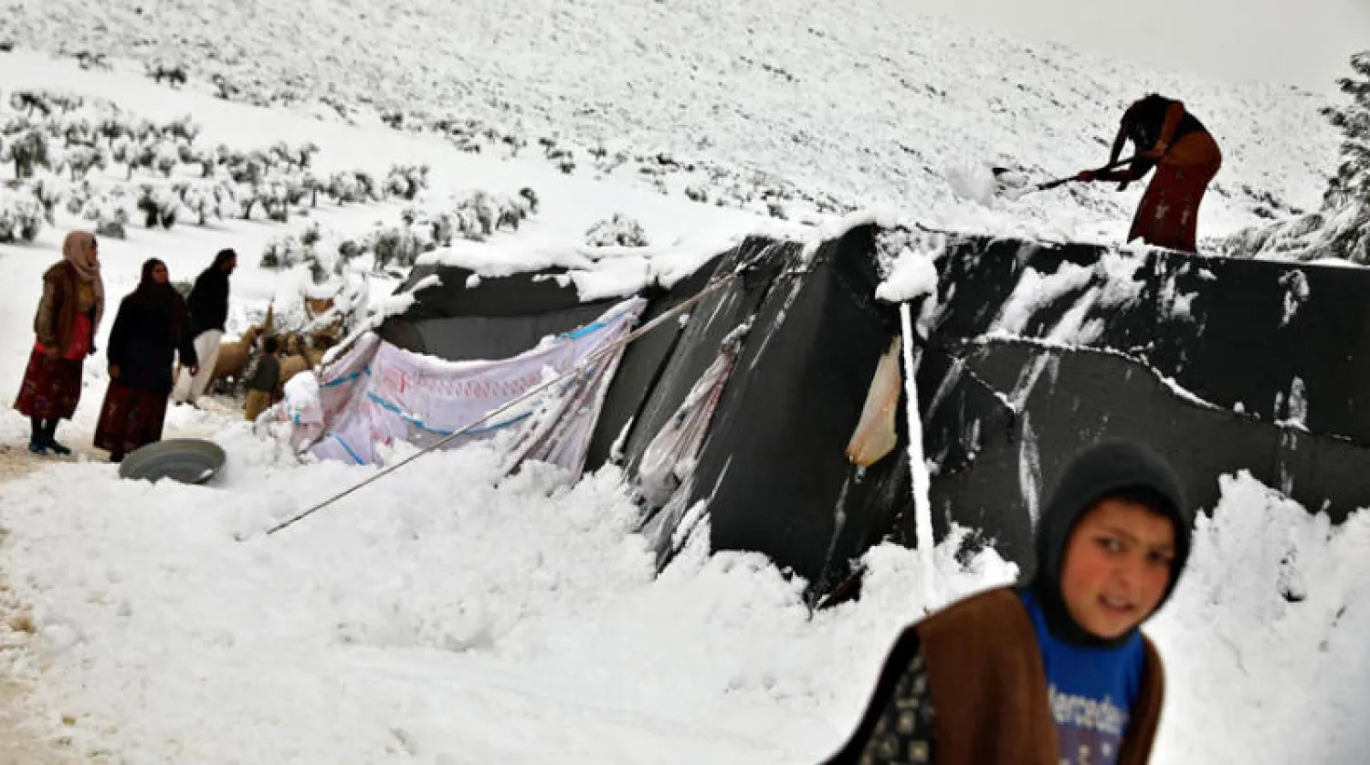 نازحون في مخيمات غطتها الثلوج شمال غربي سوريا أمس (أ.ف.ب)