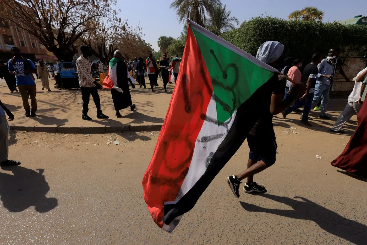 A person carries a Sudanese flag during a rally against military rule following last month's coup in Khartoum, Sudan, January 13, 2022. (Reuters)