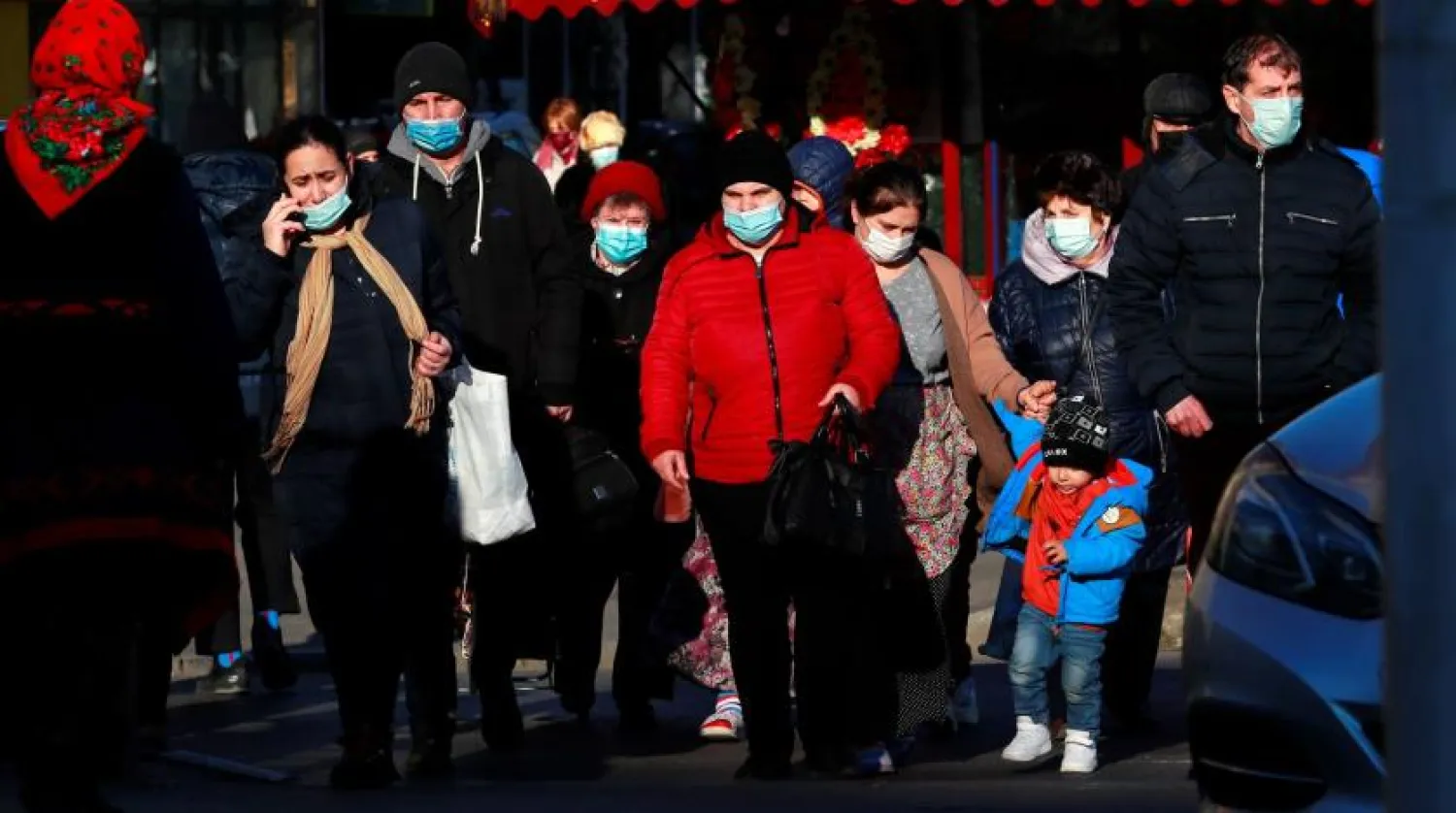 People wearing face masks cross the street in Bucharest, Romania, 20 January 2022. EPA/ROBERT GHEMENT