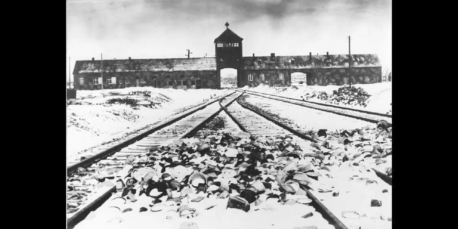 FILE- This February/March 1945, file photo shows the entry to the concentration camp Auschwitz-Birkenau in Poland, with snow covered rail tracks leading to the camp. (AP Photo/Stanislaw Mucha, File)


