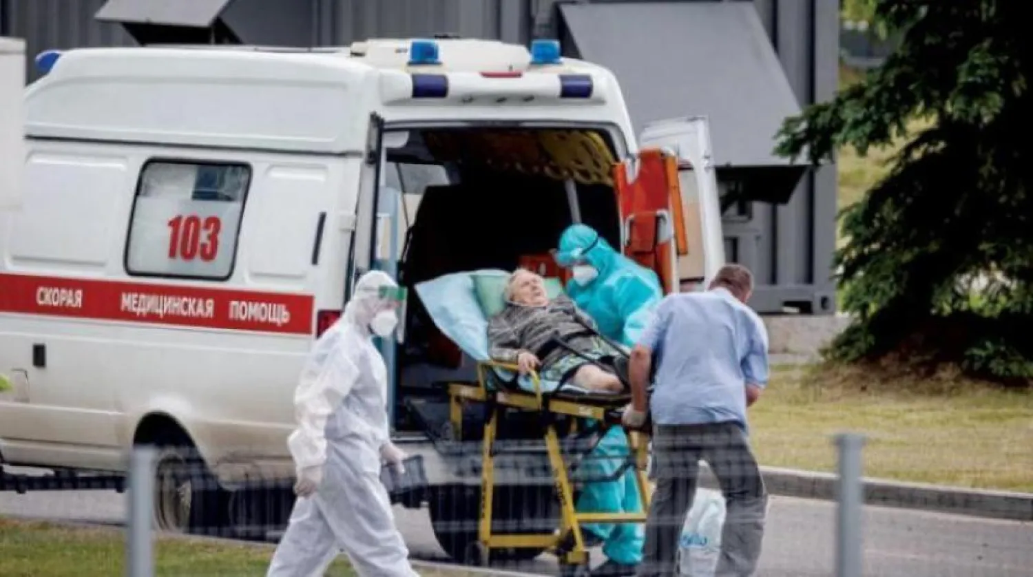 Bir sağlık personeli, bir Corona hastasına Moskova'nın eteklerinde bir hastaneye kadar eşlik ediyor (AFP)
