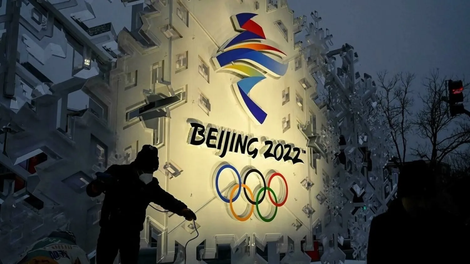 Workers set up an installation displaying the logo of the Beijing Winter Olympics. (AFP)